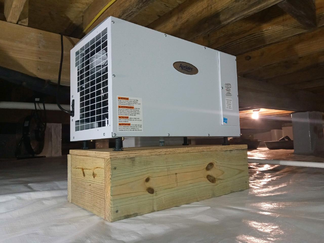 A white air conditioner sitting on top of a wooden box.